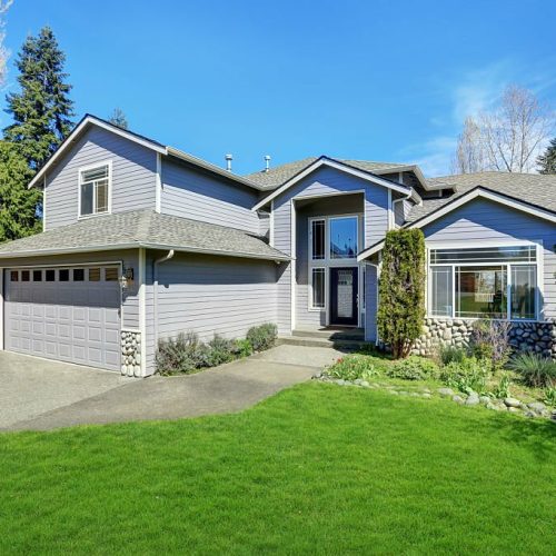 Traditional blue home exterior in Puyallup with wood siding and elegant front door. Northwest, USA