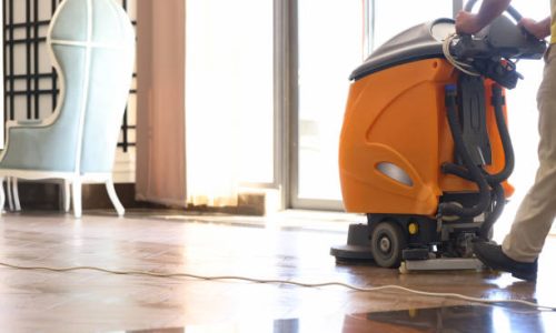 Cleaner washing floor in hotel using special machine closeup. Professional office cleaning concept