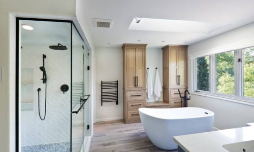 A contemporary modern bathroom design. featuring a freestanding bathtub and a glass shower stall