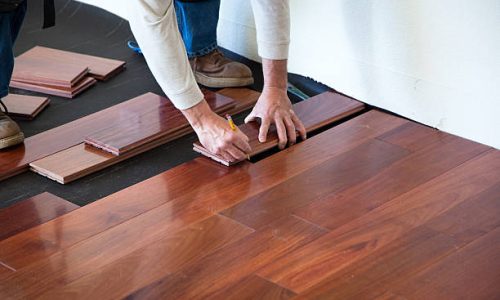 A worker installing hardwood floor in an American upscale home.A worker installing hardwood floor in an American upscale home.